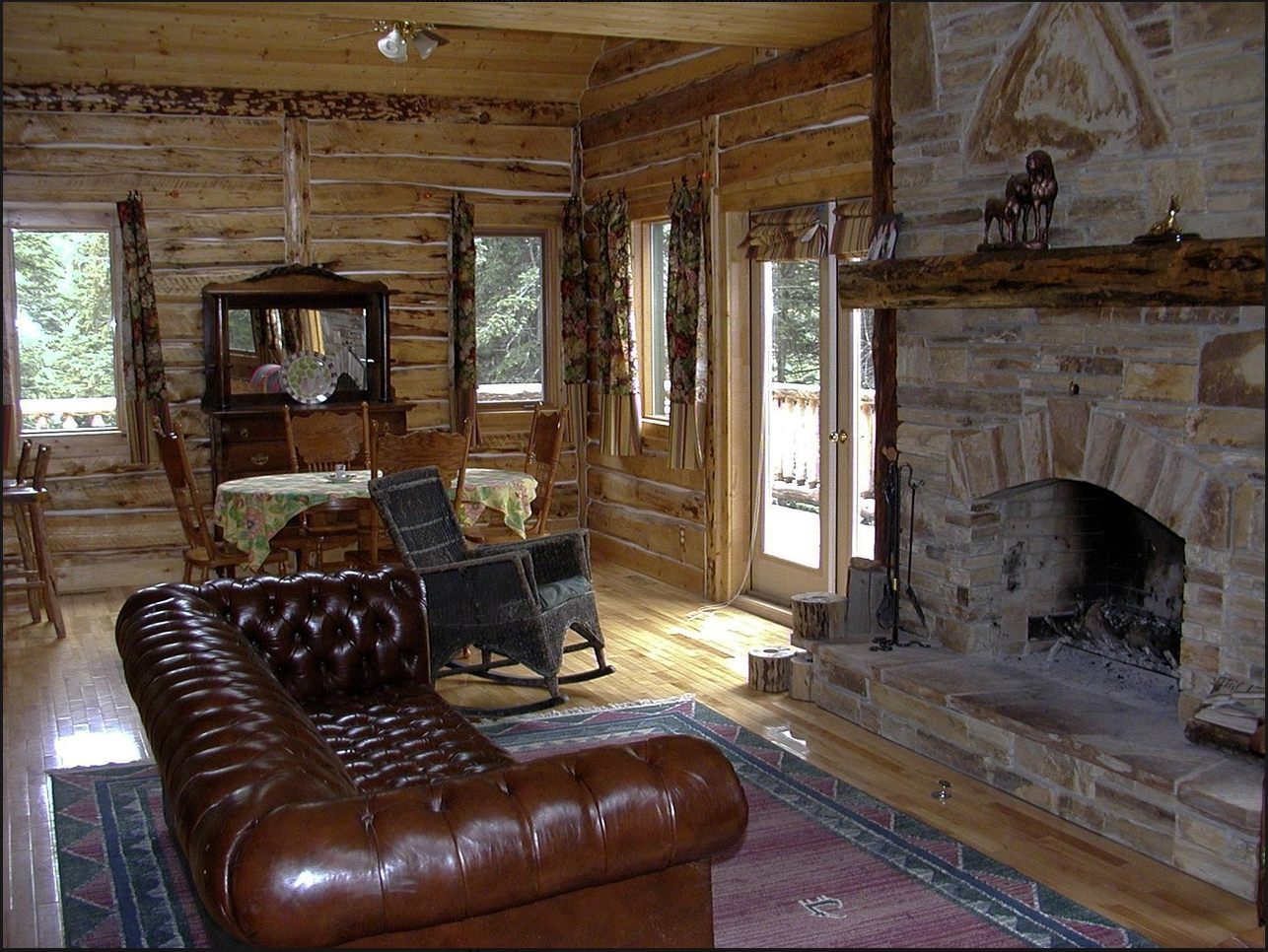 Rustic log-cabin interior with stone fireplace and wood paneling